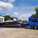 Motoryacht auf dem Tiefladerauflieger auf dem Werftgelände der Bootswerft Baumgart vor der Lackierhalle