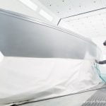 Stefan Baumgart in Schutzkleidung bei Bootslackierarbeiten in der Lackierkabine der Bootswerft Baumgart in Dortmund