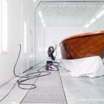 Stefan Baumgart in Schutzkleidung bei Holzlackierarbeiten in der Lackierkabine der Bootswerft Baumgart in Dortmund