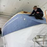 Fertig geschliffene Comfortina 38 Segelyacht vor der Lackierung in der grossen Lackierkabine der Bootswerft Baumgart in Dortmund. Das Unterwasserschiff und das Deck sind bereits mit Papier abgedeckt.