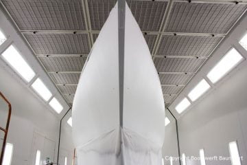 Der Rumpf der Comfortina 38 Segelyacht ist jetzt weiss grundiert in der Lackierkabine der Bootswerft Baumgart in Dortmund