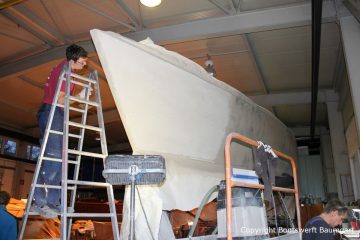 Kleine Unebenheiten am Rumpf der Comfortina 38 Segelyacht werden beseitigt. Stefan Baumgart bei den Arbeiten in der Werfthalle der Bootswerft Baumgart in Dortmund