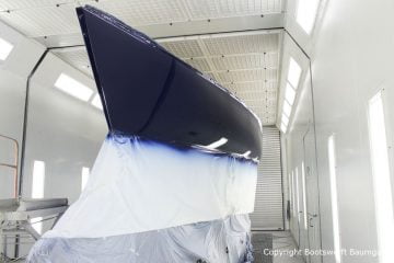 Erste Lackschicht in dunkelblau auf der Comfortina 38 Segelyacht. Backbordseite in der Lackierkabine der Bootswerft Baumgart in Dortmund