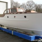 Grundierter Rumpf der Rapsody 29 vor der Lackierkabine auf dem Werftgelände der Bootswerft Baumgart in Dortmund