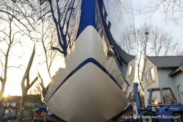 Bug und Wasserpass der Latitude 46 Tofinou 9.5 nach Fertigstellung der Neulackierung in Royal Blue von AWL Grip Yachtfarben auf dem Werftgelände der Bootswerft Baumgart in Dortmund