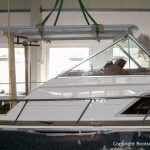 Das Dach der Chris Craft MX 25 Motoryacht wird beim Refit für die Lackierung mit dem Deckenkran in der Werfthalle der Bootswerft Baumgart in Dortmund abgenommen