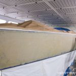 Schleifarbeiten am Rumpf einer Comfortina 38 in der Lackierkabine der Bootswerft Baumgart in Dortmund