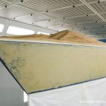 Schleifarbeiten am Rumpf einer Comfortina 38 in der Lackierkabine der Bootswerft Baumgart in Dortmund