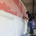Schleifarbeiten am Rumpf einer Comfortina 38 in der Werfthalle der Bootswerft Baumgart in Dortmund